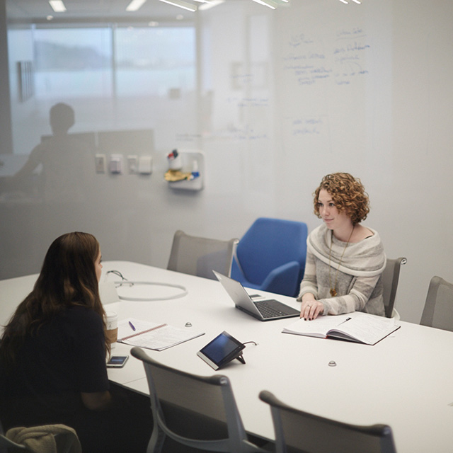 Two people sitting at a conference table.